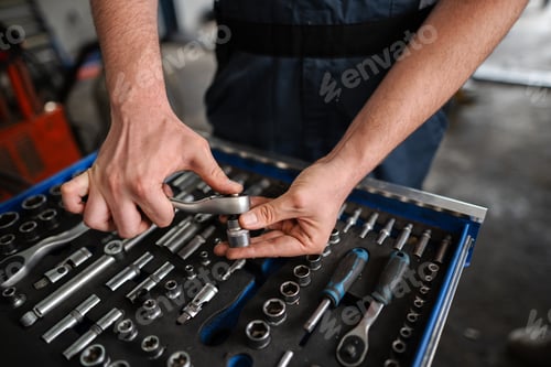 Preview: Mechanic selecting socket wrench from toolbox in workshop