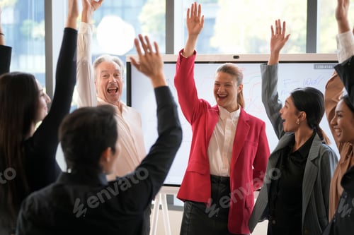Preview: Diverse business team celebrating success with raised hands in a modern office setting
