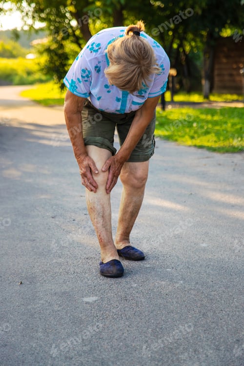 Preview: Old woman hurts her knee. Selective focus.