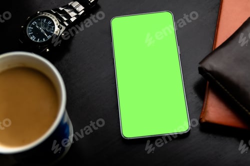 Preview: Green screen smartphone on the desk with a coffee tea cup and wristwatch