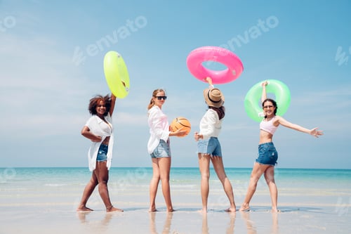 Preview: roup of teenage with floaty on the beach having fun in a sunny day