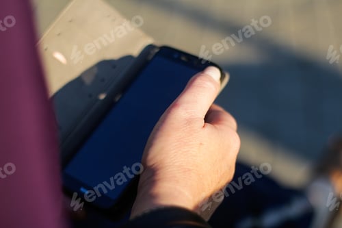 Preview: close-up female hands searching on the phone outside, outdoor.