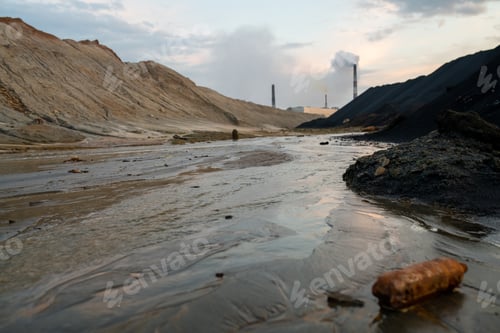 Preview: View of road with mud and big puddles or river surrounded by polluted hills and industrial factories