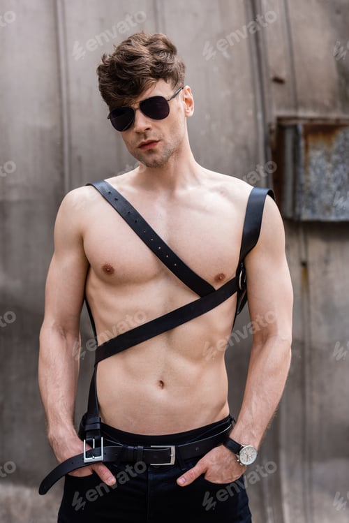 Preview: sexy shirtless man in sunglasses and sword belt with hands in pockets