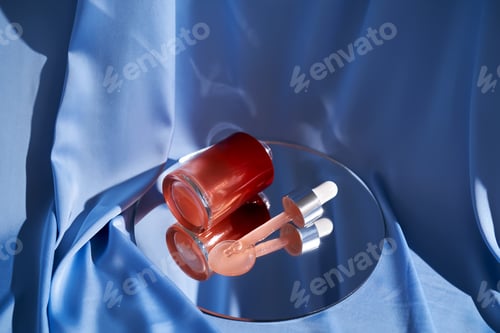 Preview: Bottle with pink serum on a blue background.
