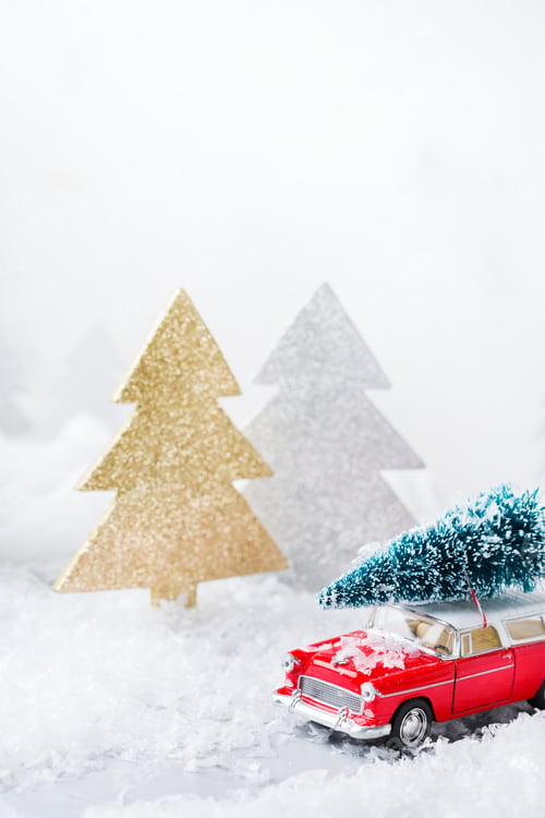 Preview: Toy car carrying christmas tree in a snow forest