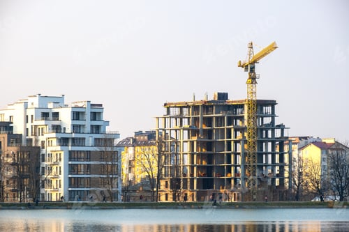 Preview: Tower crane and high residential apartment buildings under construction on lake shore