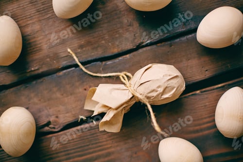 Wooden Eggs and Paper Wrapped Egg on Wood