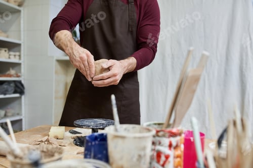 Preview: Creative couple molds pottery together in a modern studio