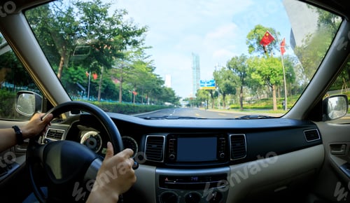 Preview: People hands holding steering wheel while driving car in modern city