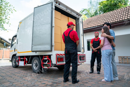 Preview: Wide shot of two delivery man opern truck door and show to couple people as customer at the house