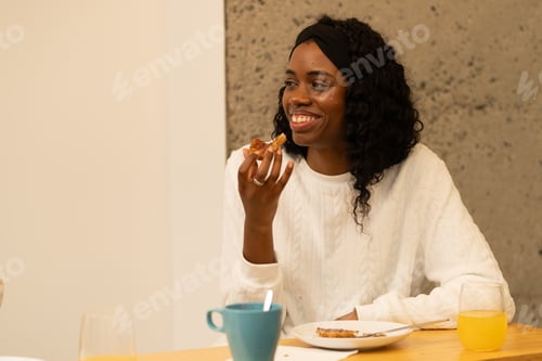 Preview: Smiling black woman enjoying jam topped toast