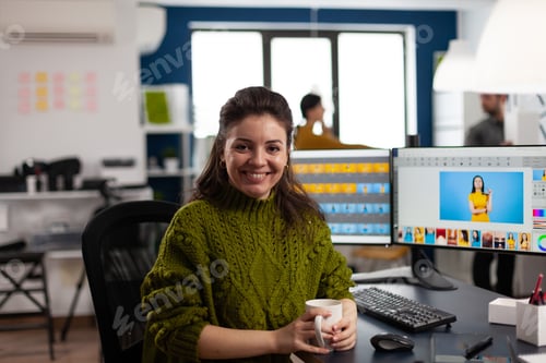 Preview: Woman retoucher looking at camera smiling sitting in creative design media agency