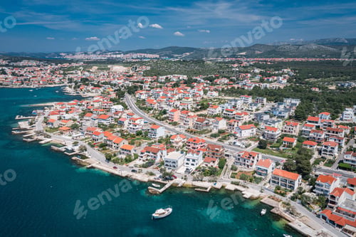 Preview: Aerial view of an idyllic coastal scene featuring a tranquil blue ocean and bright white buildings