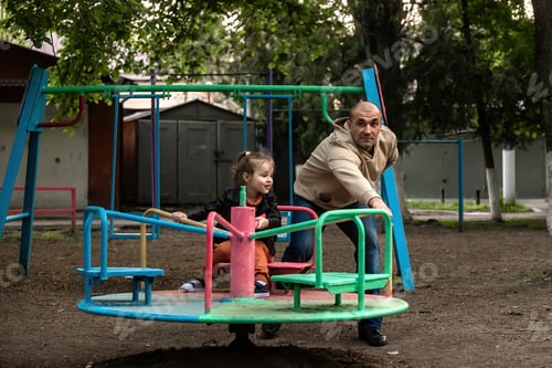 Preview: family having fun on the playground on a swing
