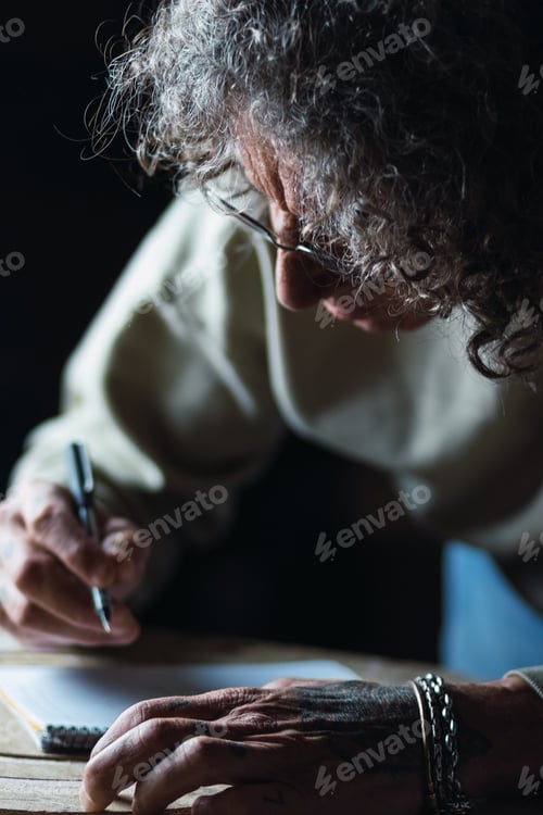 Preview: Male carpenter creating sketch in notebook in workshop