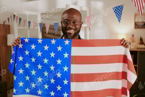 Preview: Portrait of Middle Aged Black Man Smiling While Holding American Flag Indoors