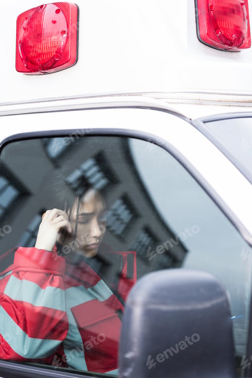 Preview: young female Asian paramedic reading something in ambulance