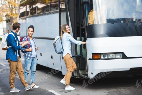 Preview: selective focus of multiethnic tourists with backpacks walking into travel bus at city street