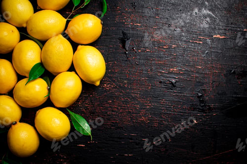 Preview: Juicy lemons with foliage on the table.