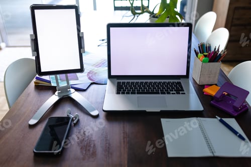 Preview: Notepad and smartphone with laptop and tablet with copy space on screens, on dining table at home