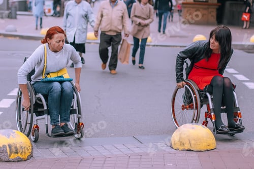 Preview: Two girls in wheelchairs are trying to cross road. city accessible to people with special needs