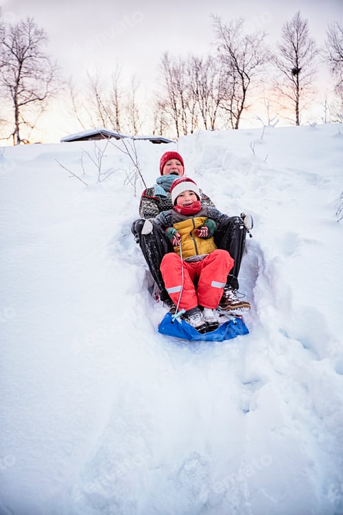 Preview: Two brothers playing on toboggan on snow covered hill, Hemavan,Sweden