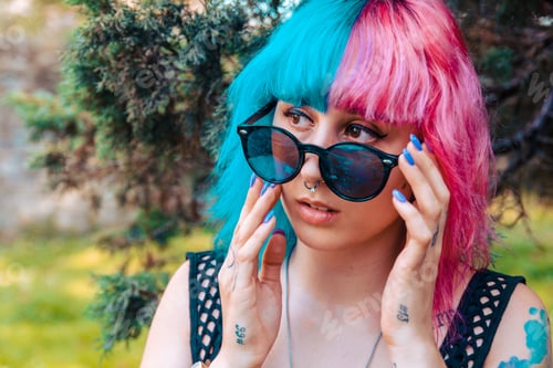 Preview: Cool girl with tattoos and colorful hair staring through her shades