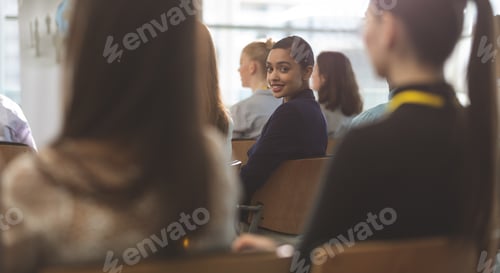 Preview: Businesswoman looking at camera during seminar in office building