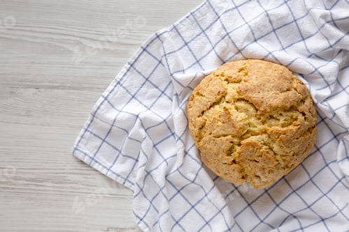 Preview: Homemade Irish Soda Bread on a white wooden surface, top view. Flat lay, overhead, from above.