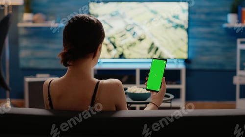 Preview: Caucasian woman holding mobile phone with green screen