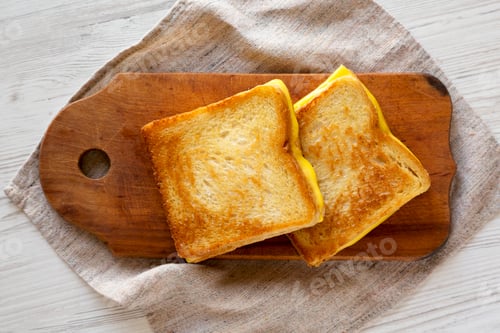 Preview: Homemade Grilled Cheese Sandwich on a rustic wooden board on a white wooden background, top view.