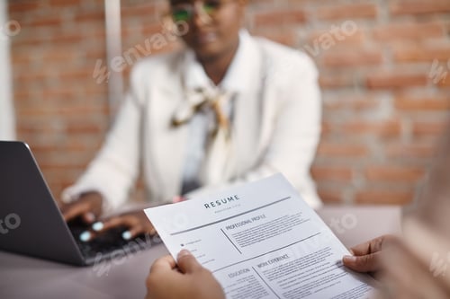 Preview: Close-up of job applicant holding her resume during an interview in the office.