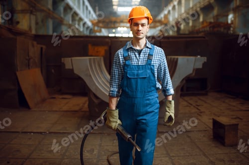 Preview: Male worker holds pneumatic jackhammer on factory