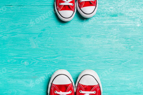 Preview: red sneakers on wooden background.