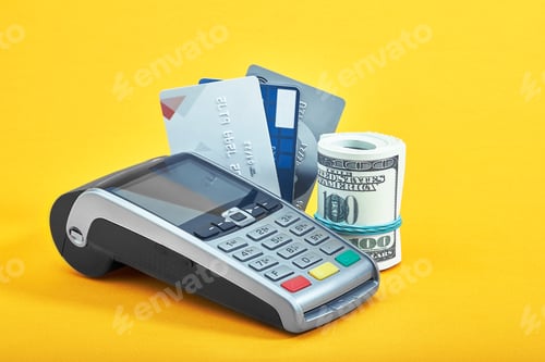 Preview: Many different credit cards, dollar bills and payment terminal on yellow background, closeup