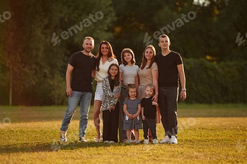 Preview: Looking forward. Family with adults and kids is standing on the field