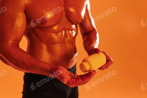 Preview: Man bodybuilder boxer with naked torso with abs holding can muscle growth pills, steroids, doping