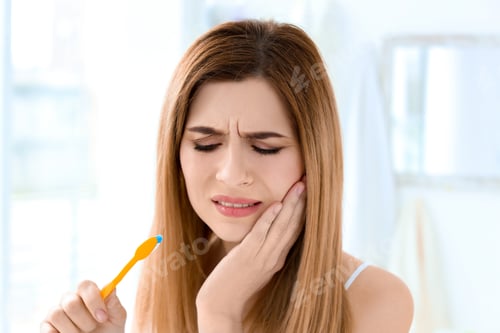 Preview: Young woman suffering from toothache indoors