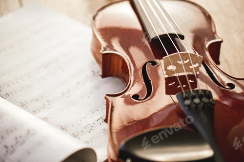 Preview: Beauty of musical instruments. Close up view of brown violin lying on sheets with music notes on
