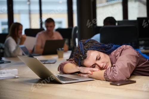 Preview: Overworked lady resting on working place with laptop