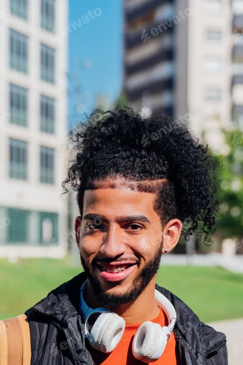 Preview: Vertical portrait of a happy latin student in the campus
