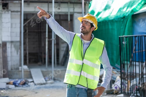 Preview: Man engineer wear uniform standing at construction site looking and pointing forward.