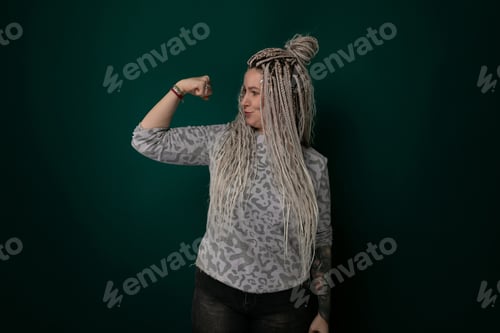 Preview: Woman With Dreadlocks Standing in Front of a Green Wall