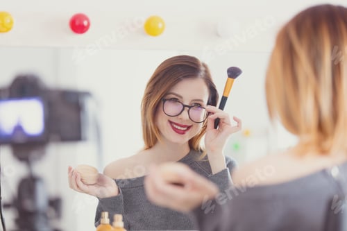 Preview: blogger woman applying cosmetics at camera