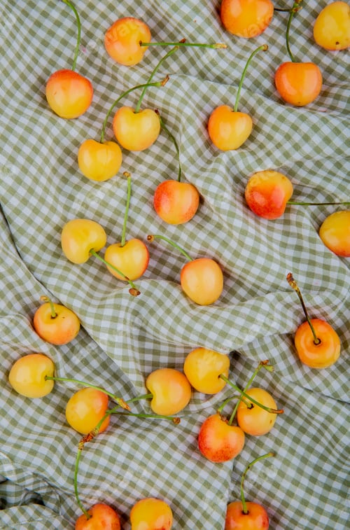 Preview: top view of yellow cherries on plaid cloth background