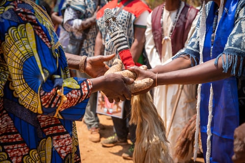 Preview: African celebration, during a funeral two people pass tubers and a ponytail to each other.