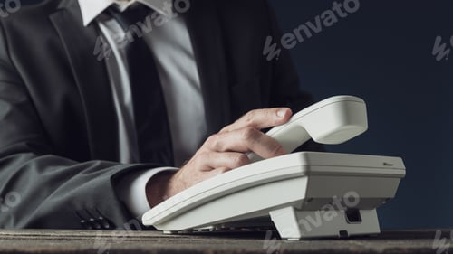 Preview: Professional Businessman Answering a White Landline Telephone