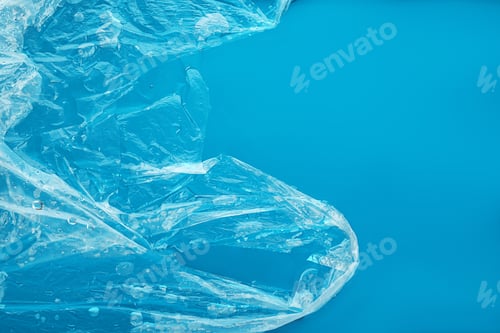 Preview: Plastic bag floating on surface of blue water, top view. Pollution concept