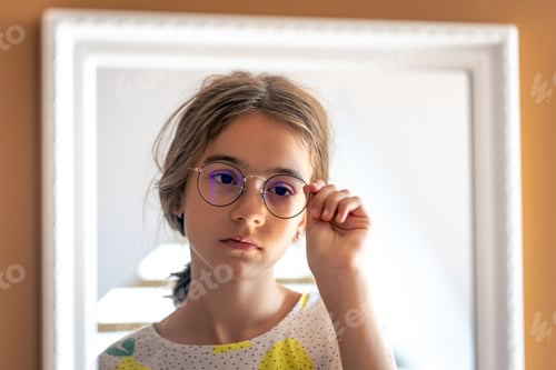 Preview: A teenage girl looks at herself in the mirror in the morning.